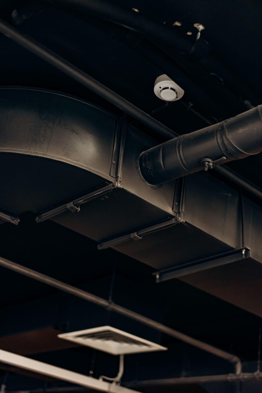 Overhead sheet-metal HVAC ductwork running along a ceiling